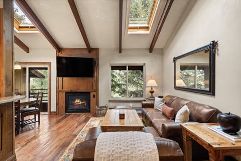 Vaulted ceilings with skylights and large pine trees out front create such an inviting retreat.