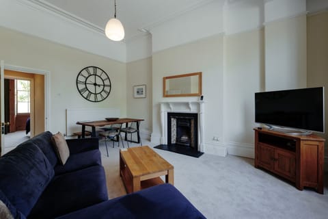The bright living room offers a stylish dining table, smart TV, and cosy sofa for relaxing stays