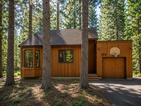 This charming wood-sided retreat is tucked among towering pines, offering a secluded forest setting. The property features a private driveway and attached garage for easy parking and storage.