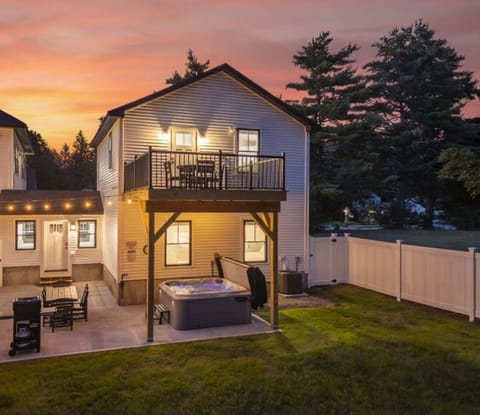 Carriage House: Irrigated Fenced-In Backyard complete with hot tub, grill, large patio with dining table, bistro lights, and 2nd level deck