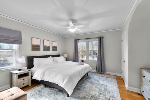 Retreat to this spacious king bedroom featuring luxurious sheets and bedding, creating the perfect place to relax and recharge after a day of exploring Omaha.