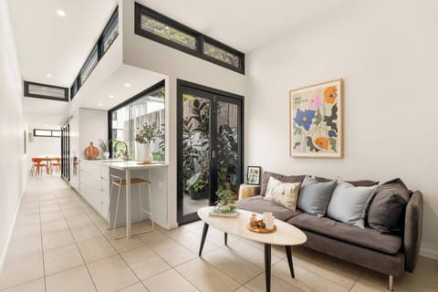 The bright open-plan living area connects seamlessly with the dining space and leafy courtyard.