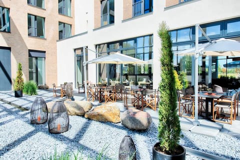 Sip morning coffee under umbrellas in a tranquil courtyard.