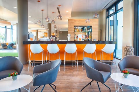 Sip cocktails at the modern bar beneath warm pendant lights.