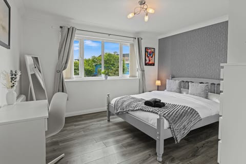 Bright modern bedroom with large window, desk space, and calming décor