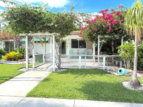 Charming tropical entrance with lush blooms and a private front patio