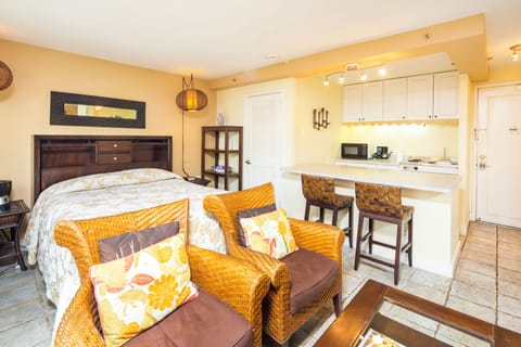 Relax in your cozy studio with a comfy bed, wicker seating, and a sleek kitchenette ready for your morning coffee or snacks.
