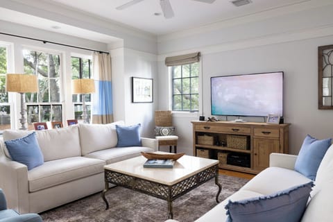 Sink into the plush sofa with blue accents, enjoy your favorite shows on the large TV, and let natural light from garden views create your perfect relaxation space.