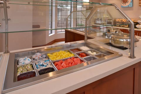 Breakfast bar displaying fresh fruits and condiments.