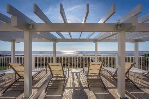 Unwind under the pergola while waves shimmer in sunlight.