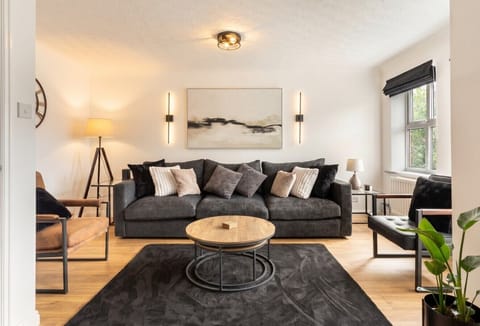 Sink into the deep grey sofa under warm mood lighting in this elegant lounge.