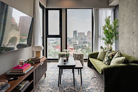Relax in the stylish living area featuring comfortable seating, modern décor, and impressive city views.