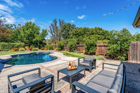Relax poolside in your private backyard oasis, where sunny afternoons and sparkling blue water invite you to unwind under the sky.