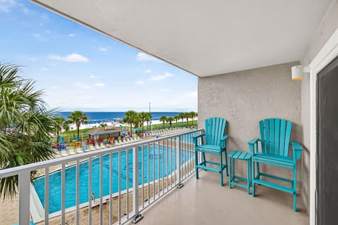 Private balcony with pool views and a stunning beachfront backdrop