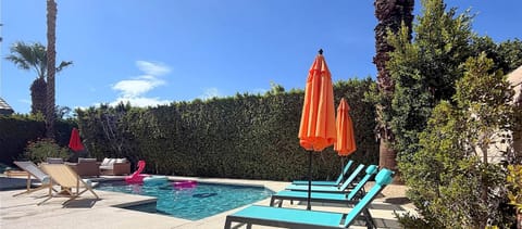 Private backyard oasis with a large pool deck, shimmering pool, and custom hot tub