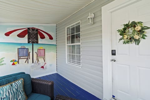 Welcome to your stay, featuring a smart lock for seamless keyless entry and a charming covered porch with comfortable outdoor seating.