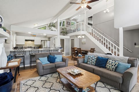 Bright open living space with vaulted ceilings, loft views, and breakfast bar