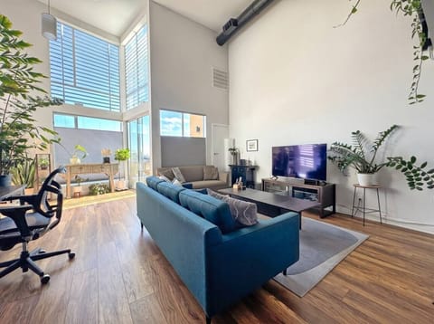 Sunlight pours through floor-to-ceiling windows onto a living room made for unwinding after a day exploring the city.