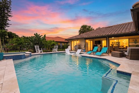 Private poolside oasis with sunset skies, lounge seating, and covered outdoor living.
