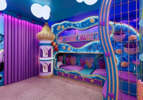 Welcome to a whimsical children's bedroom in vibrant blues and purples that ignite imagination. The unique bunk bed and colorful ocean decor create a playful vibe, while the soft carpet ensures comfort for all their fun.