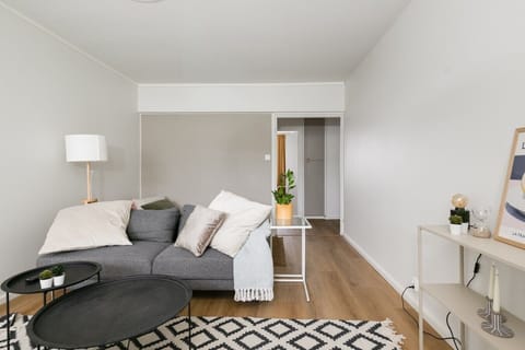 Living room wide with tripod floor lamp and shelving unit - Sammonkatu 5 B 22