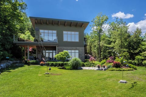 The home's striking exterior is complemented by manicured gardens and a spacious waterfront lawn.