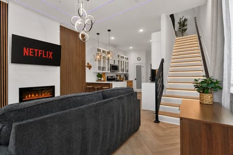 Modern open-plan lounge & kitchen, fireplace, LED-lit staircase