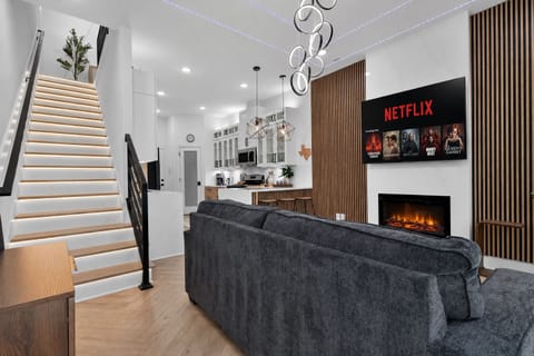 Stylish open lounge with LED stairs, fireplace, and smart TV for movie nights