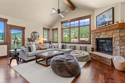 Unwind in this inviting living space where mountain views frame your relaxation. Sink into plush seating by the stone fireplace, enjoying your perfect mountain retreat.