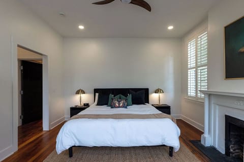 Bright, elegant bedroom with hardwood floors and a charming fireplace