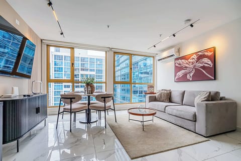 Bright living area with floor-to-ceiling windows and city views.