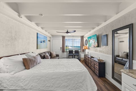Your bright, spacious retreat invites relaxation with coastal-inspired decor, soaring beamed ceilings, and an open layout that flows seamlessly to ocean views just beyond the window.