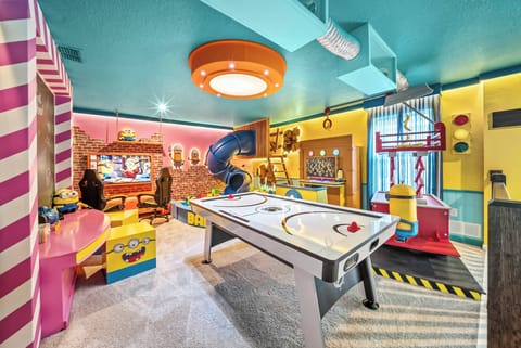 Experience our lively game room, adorned with vibrant decor and a sleek air hockey table. The bold turquoise ceiling and cheerful accents set an energizing mood, making it the perfect spot for unforgettable family fun.