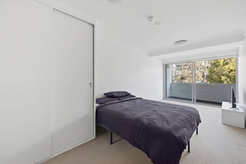 Studio bedroom with queen bed and balcony access