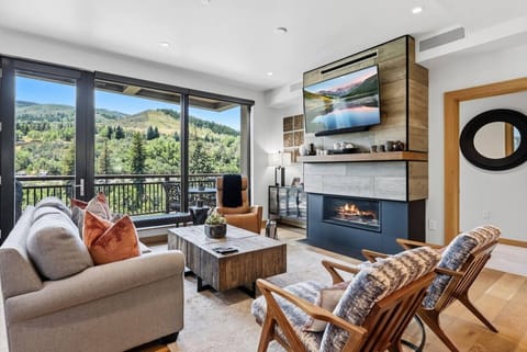 Living room with large windows, fireplace, and smart tv