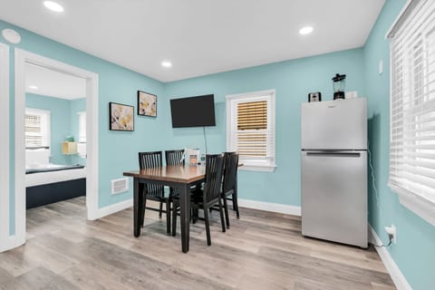 Bright dining nook with TV, coffee station, and full-size fridge