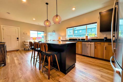 The heart of the home — granite island with seating, stainless appliances, and pendant lighting.