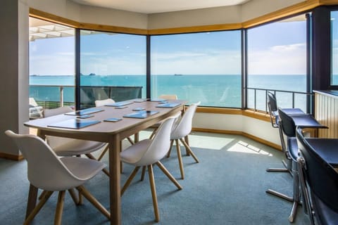 Oceanview dining room with panoramic windows and balcony access