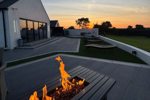 Wrap around patio with two love island seating areas hottub, sauna and outdoor bar with mountain views