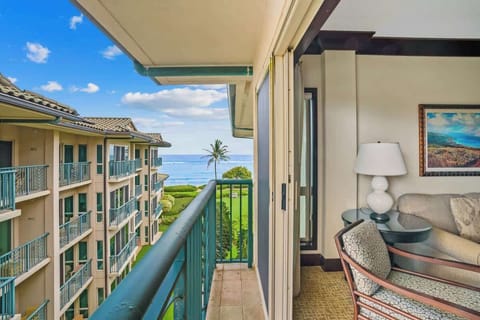 The property features ocean views with tropical landscaping, adjacent buildings, and convenient balcony access from interior living spaces.