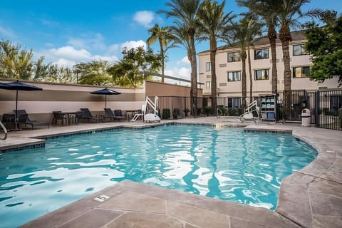Dive into sunlit pool bliss surrounded by swaying palms.