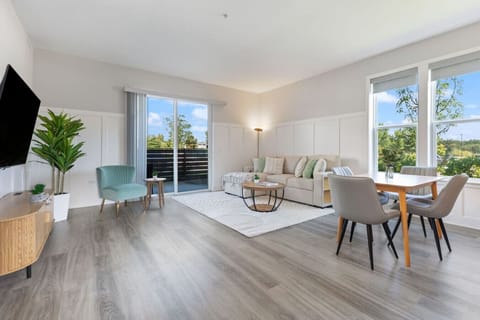 Stylish living room with a smart TV, comfortable seating, and a dedicated dining area for evening entertainment.