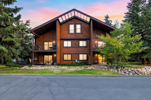 Exterior front view of the multi-level wooden lodge building illuminated at dusk.