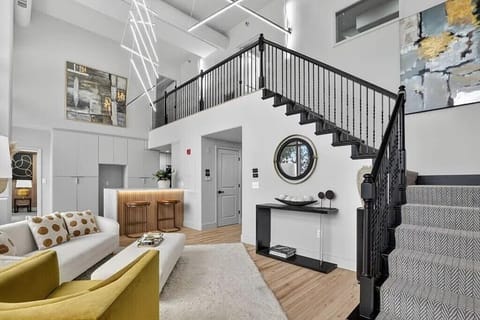 Open-concept living space featuring dramatic staircase.