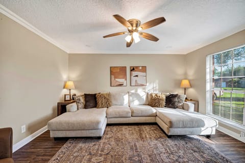 Spacious Living Area: Unwind after a day of adventure in this light-filled living area featuring a plush sectional sofa, double chaises, an oversized area rug, and a modern ceiling fan for maximum airflow.