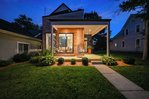 Modern covered patio with hanging chairs and glowing evening ambiance