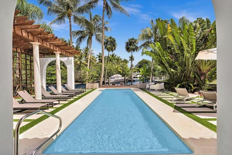 Pristine lap pool featuring a shaded loggia and tropical landscaping.