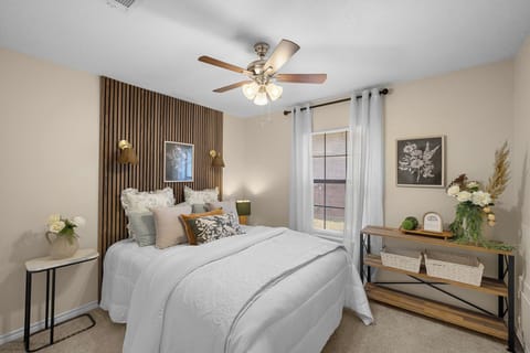 Cozy, stylish bedroom with accent wall, natural light, and warm decor