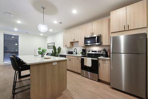 Contemporary kitchen featuring stainless steel appliances, ample storage, and a spacious island with seating.