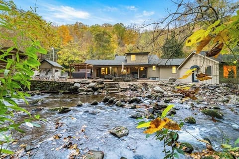 A picturesque property nestled beside a flowing stream, surrounded by autumn foliage and natural mountain beauty—your private riverside retreat awaits.